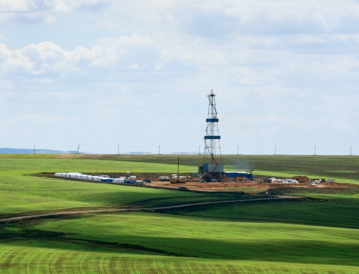 A picture of an oil well in green pasture.